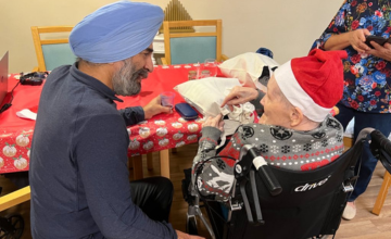 Cllr Jas Athwal speaking to an elderly care home resident