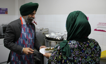 Leader of Redbridge Council distributing a hot meal to a local person