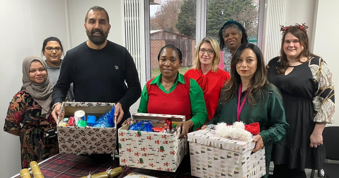 Deputy Leader of Redbridge Council standing with staff and Christmas hampers