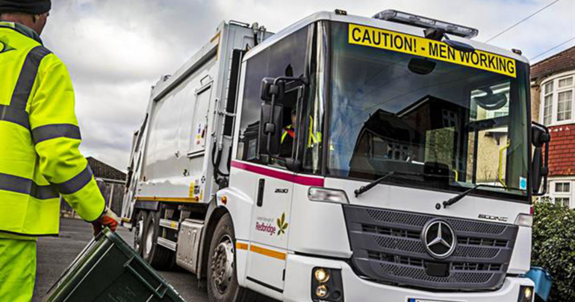 Refuse worker standing next to vehicle